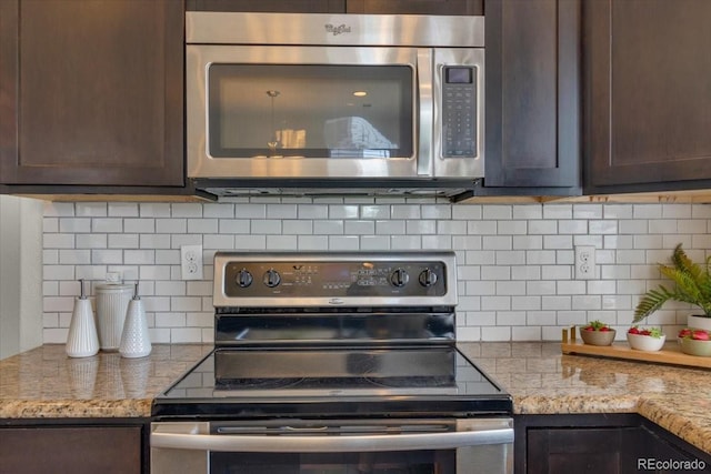 5558 Malta St, Denver, CO 80249 - kitchen featuring stainless steel appliances, dark brown cabinets, backsplash, and light stone counters