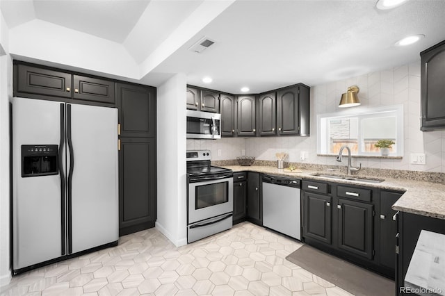 kitchen with decorative backsplash, visible vents, appliances with stainless steel finishes, and a sink