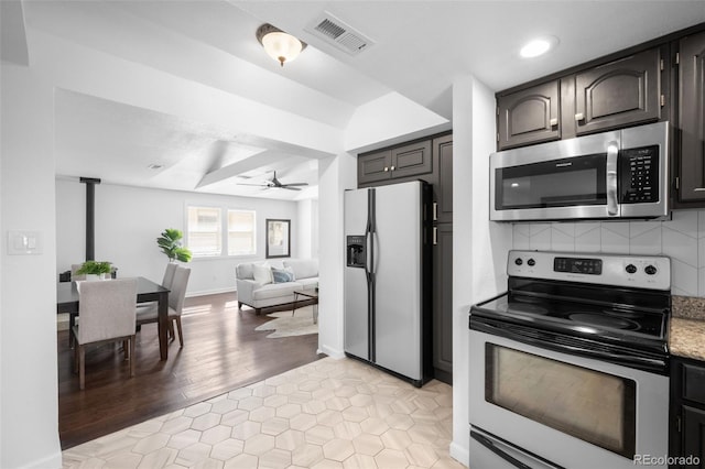 kitchen featuring visible vents, ceiling fan, decorative backsplash, stainless steel appliances, and open floor plan