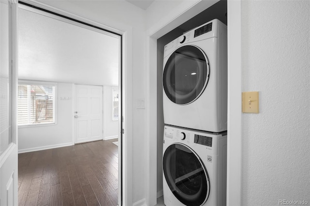 washroom with laundry area, stacked washer and dryer, baseboards, and dark wood-style flooring