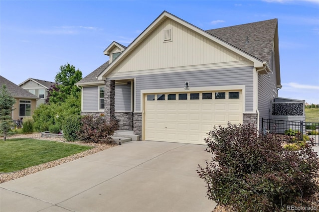 5280 Genoa St, Denver, CO 80249 - craftsman-style home with stone siding, a garage, concrete driveway, roof with shingles, and a front lawn