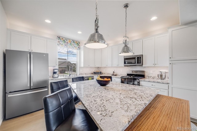 5280 Genoa St, Denver, CO 80249 - kitchen featuring stainless steel appliances, a center island, white cabinets, and recessed lighting