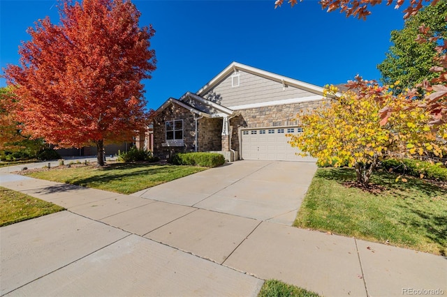 view of front of property featuring a garage, a front yard, concrete driveway, and stone siding