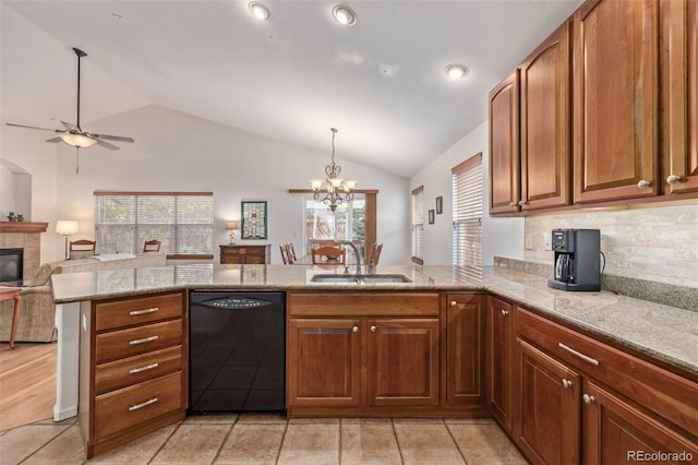 kitchen featuring a peninsula, a tile fireplace, a sink, black dishwasher, and open floor plan