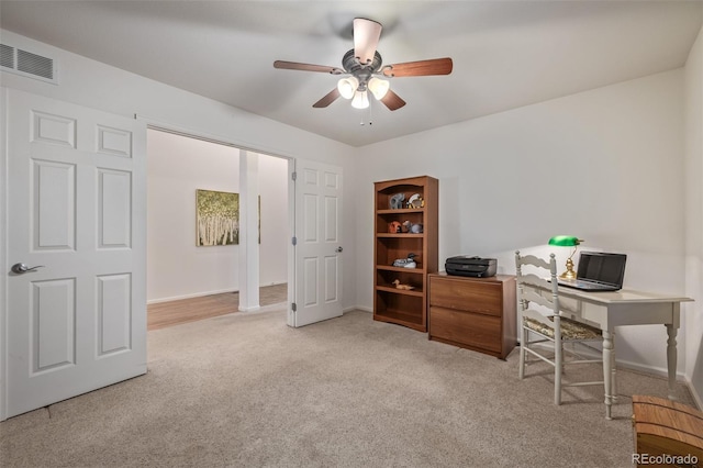 office space with baseboards, visible vents, a ceiling fan, and carpet