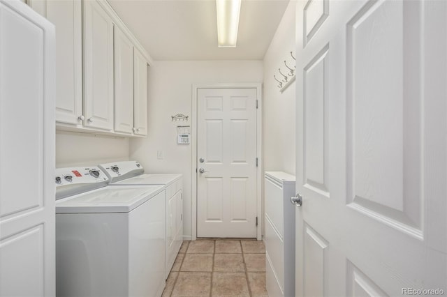 washroom featuring cabinet space, light tile patterned floors, and washer and dryer