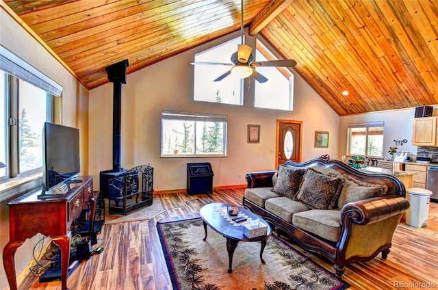 36 Gitche Goone Ln, Como, CO 80432 - living area with a wood stove, ceiling fan, a wood ceiling with exposed beams, light wood-style floors, and high vaulted ceiling