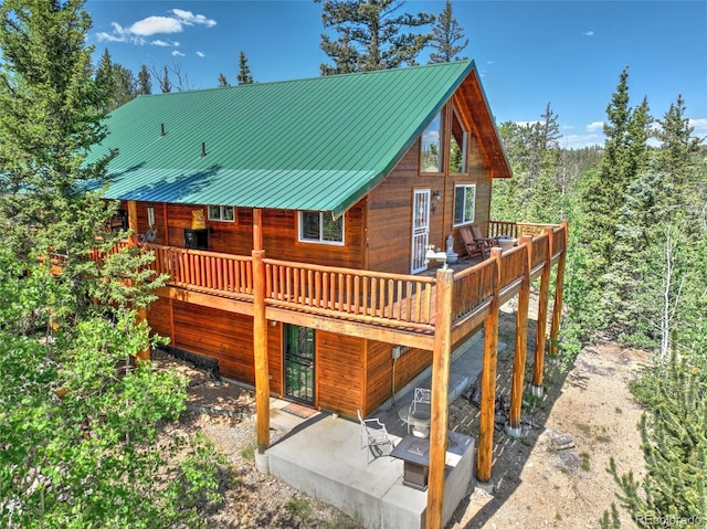 36 Gitche Goone Ln, Como, CO 80432 - rear view of house with a patio area, a wooden deck, a metal roof, and a forest view