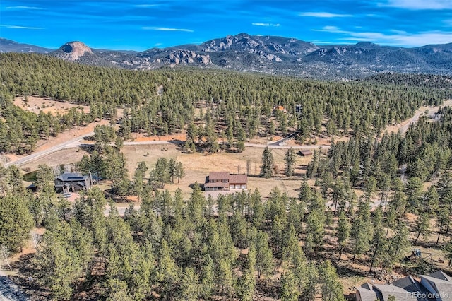 drone / aerial view featuring a wooded view and a mountain view