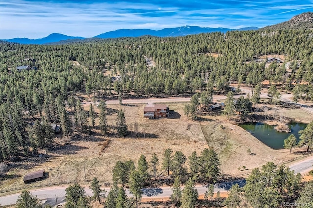 birds eye view of property featuring a mountain view and a wooded view