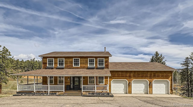 view of front facade featuring covered porch, an attached garage, and concrete driveway
