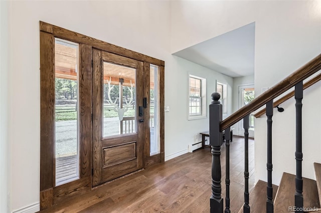 entrance foyer featuring dark wood-style flooring, baseboards, baseboard heating, and stairway