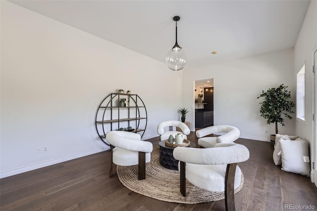living area with baseboards and wood finished floors