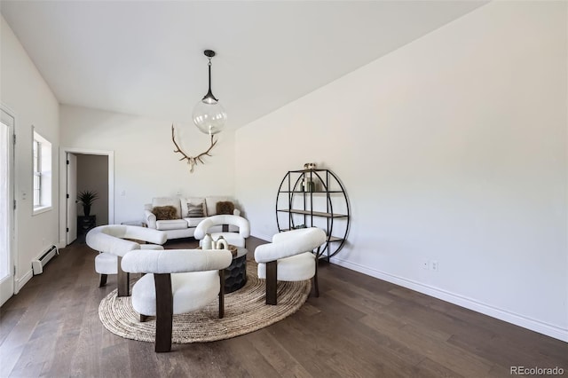 sitting room with baseboards, a baseboard heating unit, and wood finished floors