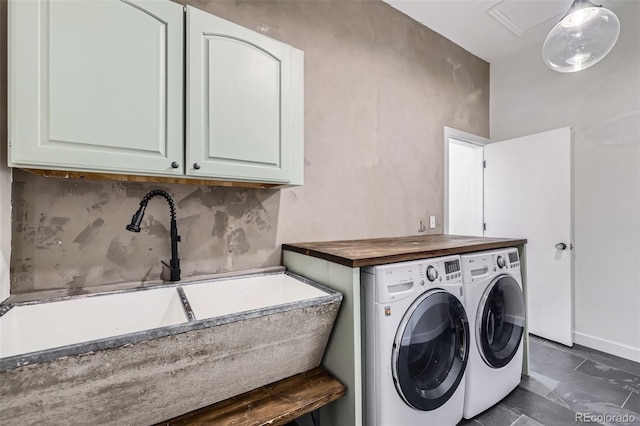 laundry room featuring cabinet space, baseboards, a sink, and washer and dryer