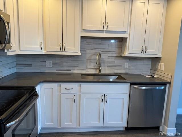 kitchen featuring appliances with stainless steel finishes, white cabinetry, sink, and backsplash