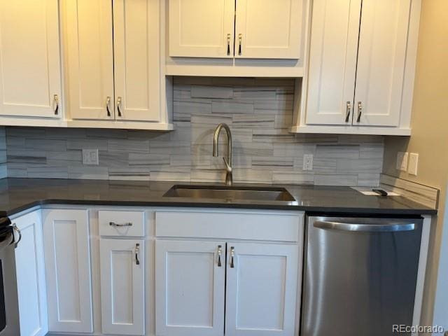 kitchen featuring stainless steel dishwasher, a sink, white cabinets, dark countertops, and tasteful backsplash