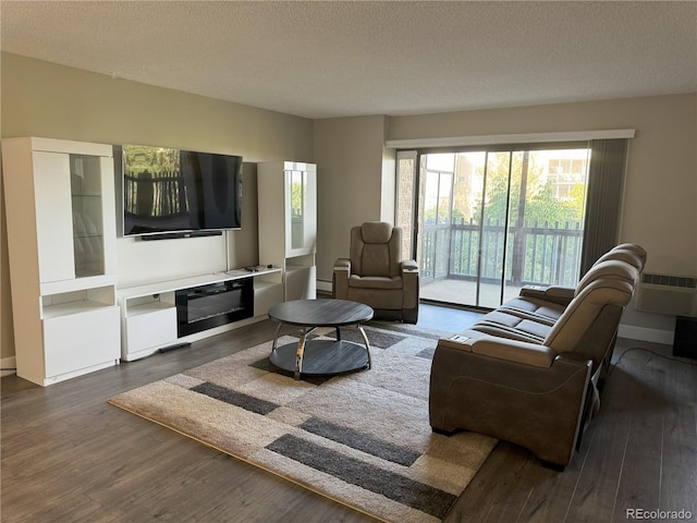 living room featuring dark wood-style floors, a textured ceiling, a wall mounted AC, and a baseboard radiator