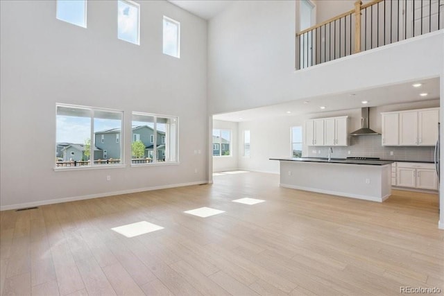 13765 Emerald Lake St, Parker, CO 80138 - unfurnished living room featuring a high ceiling, light wood finished floors, healthy amount of natural light, and recessed lighting
