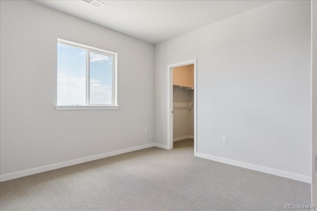 13765 Emerald Lake St, Parker, CO 80138 - unfurnished bedroom featuring light carpet, a walk in closet, and a closet