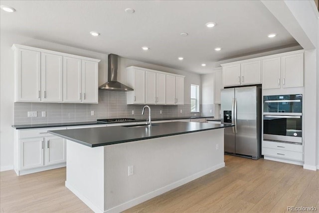 13765 Emerald Lake St, Parker, CO 80138 - kitchen with appliances with stainless steel finishes, wall chimney exhaust hood, dark countertops, light wood finished floors, and recessed lighting