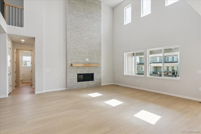 13765 Emerald Lake St, Parker, CO 80138 - unfurnished living room featuring a high ceiling, wood finished floors, and a fireplace