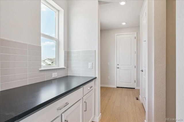 13765 Emerald Lake St, Parker, CO 80138 - kitchen with dark countertops, light wood finished floors, white cabinets, decorative backsplash, and recessed lighting