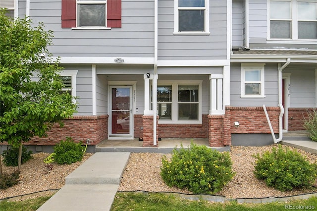 5813 Ceylon St, Denver, CO 80249 - property entrance featuring a porch and brick siding
