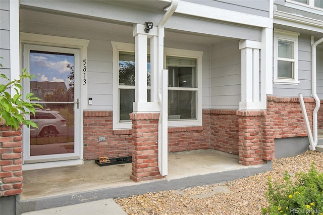 5813 Ceylon St, Denver, CO 80249 - view of exterior entry with a porch and brick siding