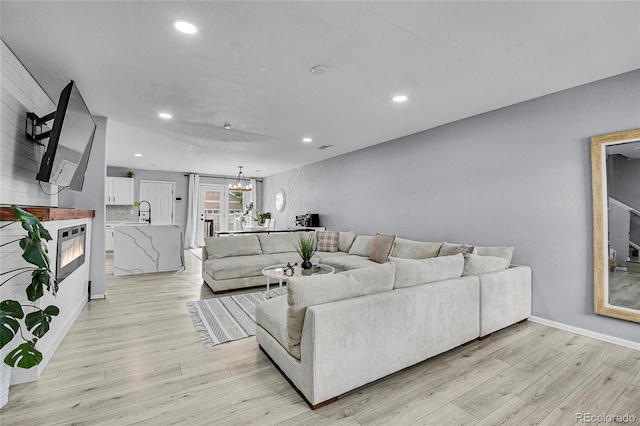 5813 Ceylon St, Denver, CO 80249 - living room featuring light wood finished floors, recessed lighting, and a chandelier