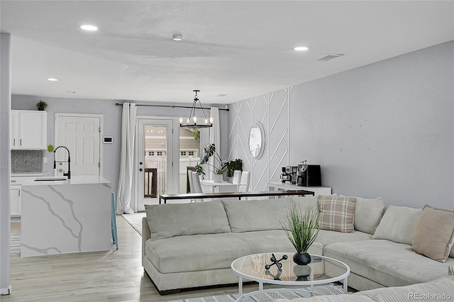 5813 Ceylon St, Denver, CO 80249 - living room with a chandelier, light wood finished floors, and recessed lighting