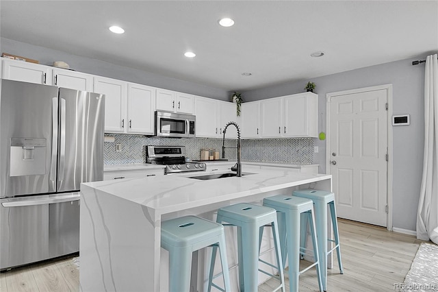 5813 Ceylon St, Denver, CO 80249 - kitchen with appliances with stainless steel finishes, decorative backsplash, white cabinetry, light stone counters, and recessed lighting