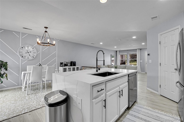 5813 Ceylon St, Denver, CO 80249 - kitchen with open floor plan, light wood-type flooring, white cabinets, recessed lighting, and appliances with stainless steel finishes