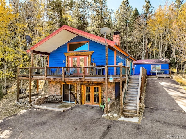 log-style house with french doors and a deck