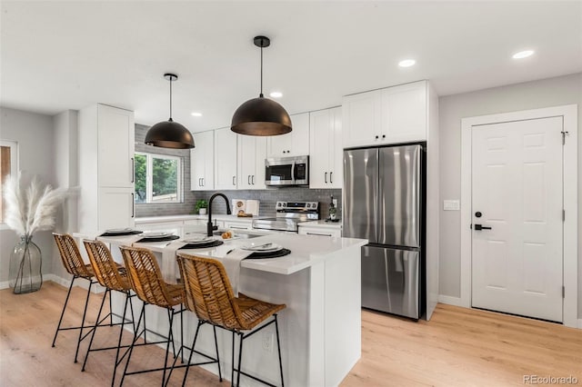 3061 S Glencoe St, Denver, CO 80222 - kitchen with stainless steel appliances, white cabinets, light wood-style floors, and recessed lighting