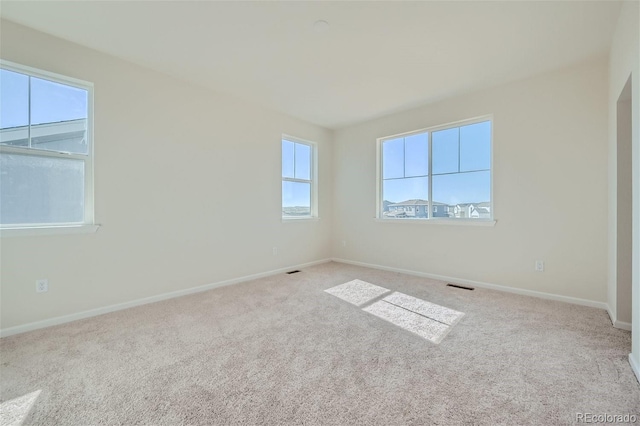 spare room featuring light carpet