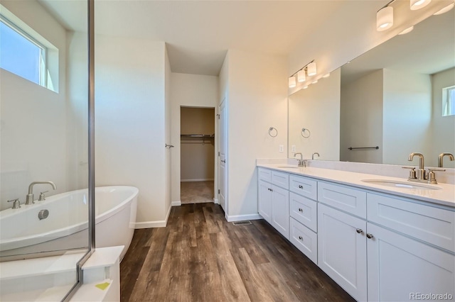 bathroom featuring a tub to relax in, hardwood / wood-style floors, and vanity