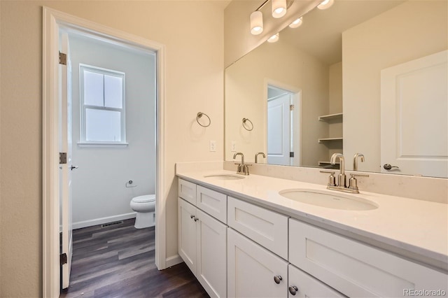 bathroom featuring vanity, hardwood / wood-style floors, and toilet