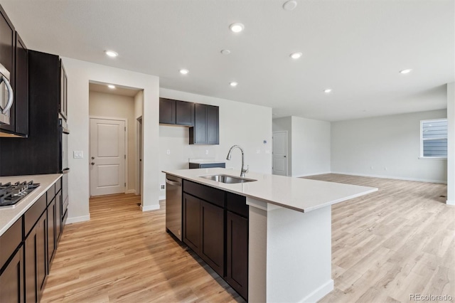 1290 Loraine Cir N, Lafayette, CO 80026 - kitchen with stainless steel appliances, light wood-type flooring, an island with sink, recessed lighting, and light countertops