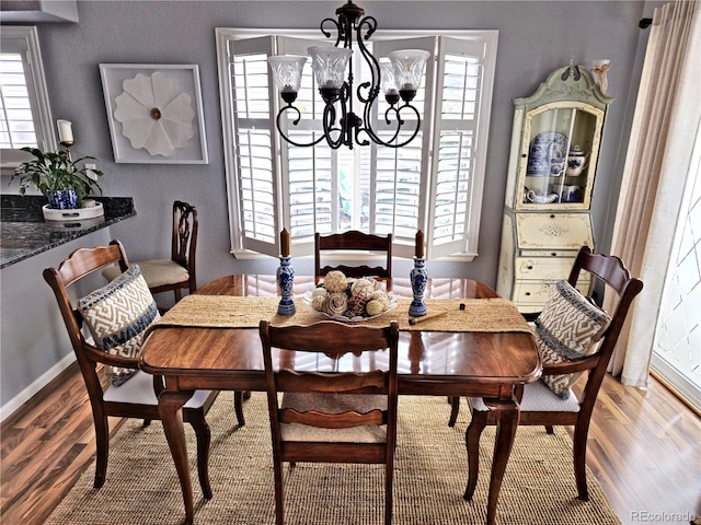 dining space featuring plenty of natural light, an inviting chandelier, and hardwood / wood-style flooring