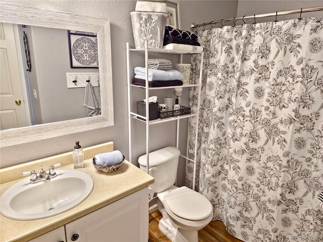 bathroom with toilet, vanity, wood-type flooring, and a shower with curtain