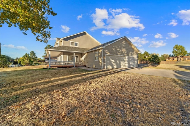 back of property with a porch, a garage, and a lawn