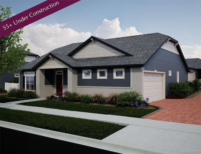 21825 E 51st Dr, Aurora, CO 80019 - view of front of home featuring an attached garage, decorative driveway, and a shingled roof