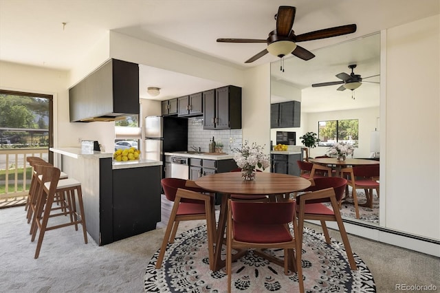 dining room featuring a baseboard heating unit, light carpet, and ceiling fan