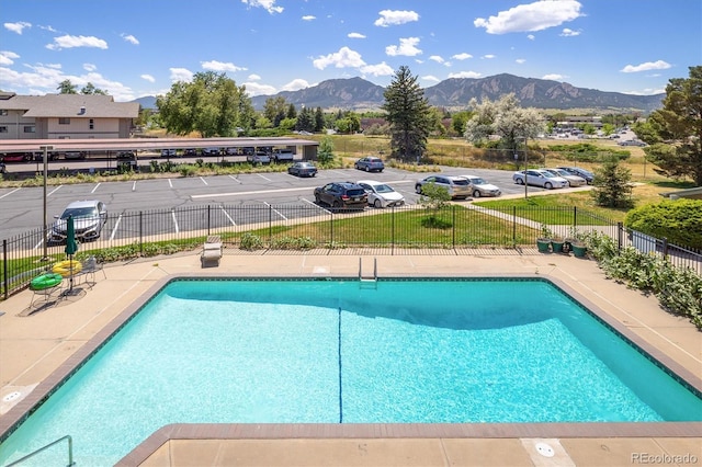 community pool featuring fence and a mountain view