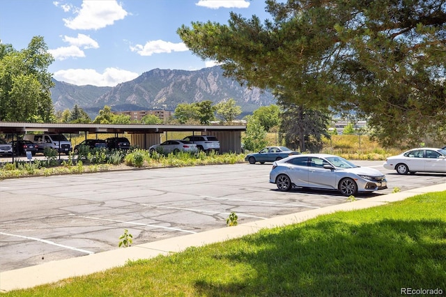 uncovered parking lot featuring a mountain view