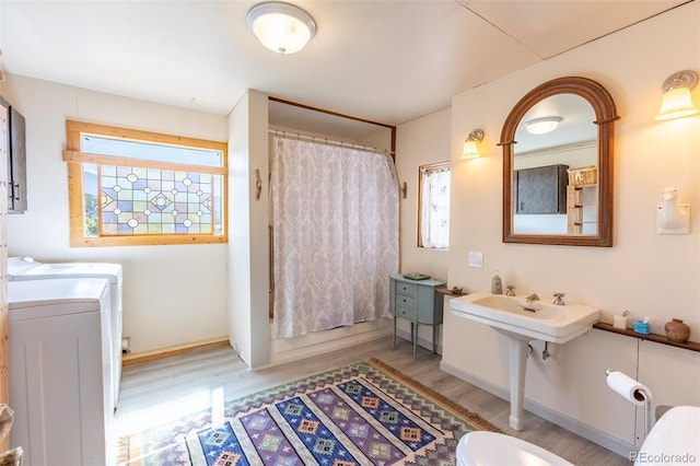 689 County Road 4, Howard, CO 81233 - full bath with washer and clothes dryer, wood finished floors, healthy amount of natural light, and curtained shower