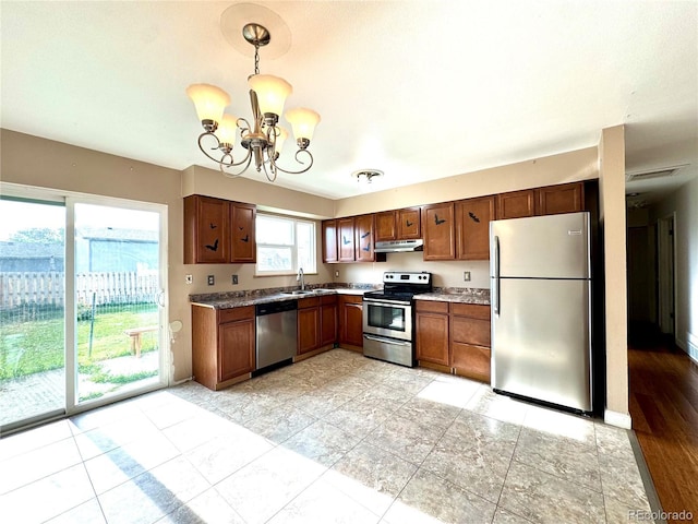 4312 S Xenon St, Morrison, CO 80465 - kitchen featuring appliances with stainless steel finishes, under cabinet range hood, a sink, a chandelier, and hanging light fixtures