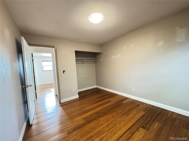 4312 S Xenon St, Morrison, CO 80465 - unfurnished bedroom with wood finished floors, baseboards, and a closet