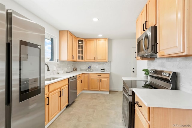 9101 Clarkson St, Thornton, CO 80229 - kitchen featuring appliances with stainless steel finishes, light brown cabinetry, a sink, glass insert cabinets, and recessed lighting